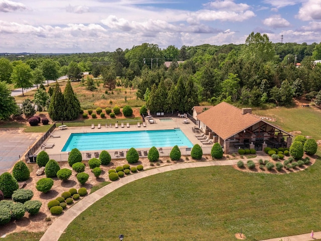 view of pool with a lawn and a patio