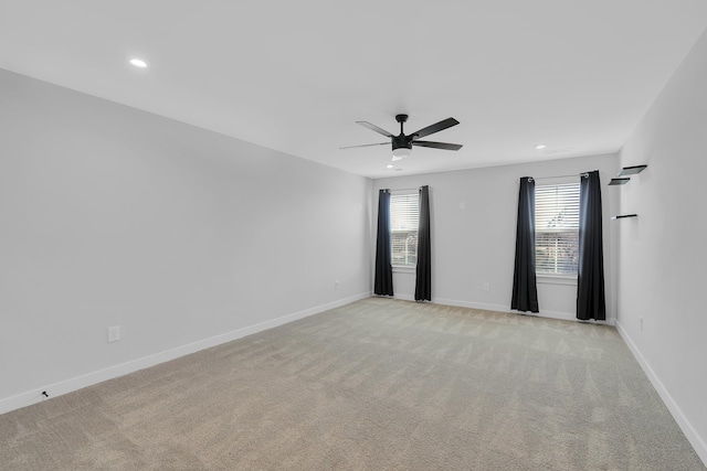 carpeted spare room featuring ceiling fan