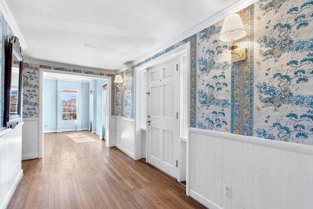 foyer with radiator heating unit, wood-type flooring, and crown molding