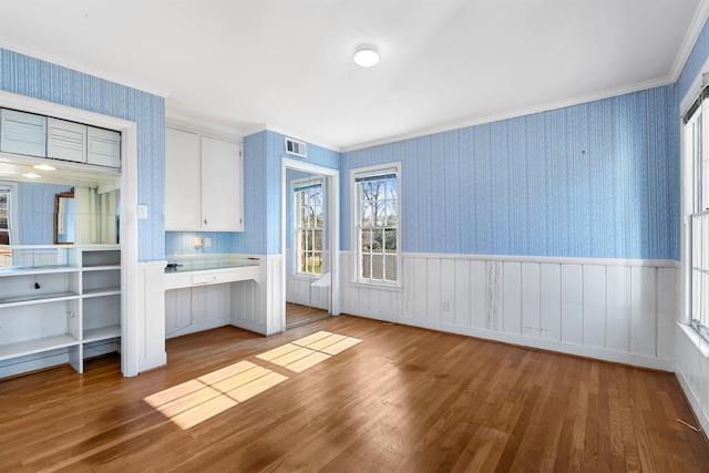 interior space featuring white cabinets, ornamental molding, and light hardwood / wood-style floors