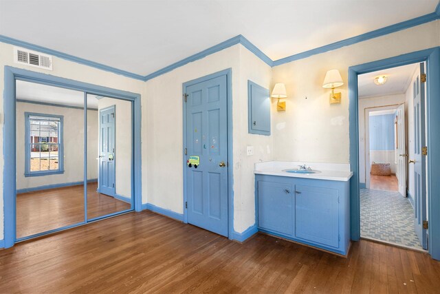 interior space with crown molding, wood-type flooring, and vanity