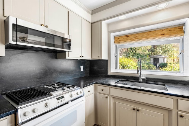 kitchen with decorative backsplash, sink, white cabinetry, and white range