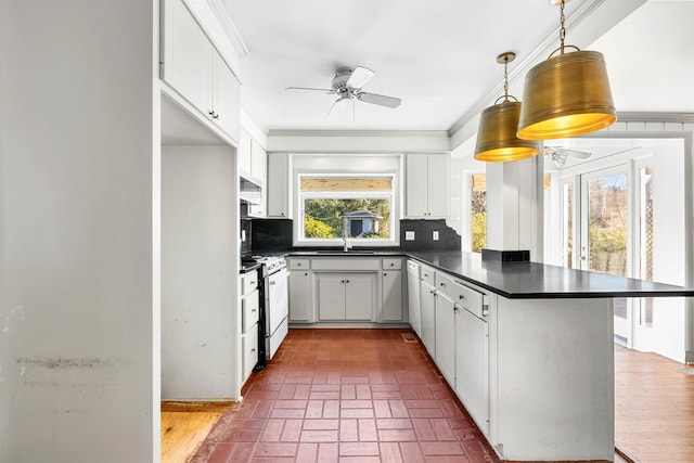 kitchen with white cabinets, kitchen peninsula, and range