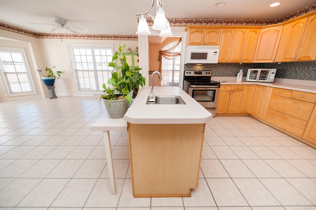 kitchen featuring pendant lighting, sink, light tile patterned flooring, a kitchen island with sink, and stainless steel range with electric cooktop