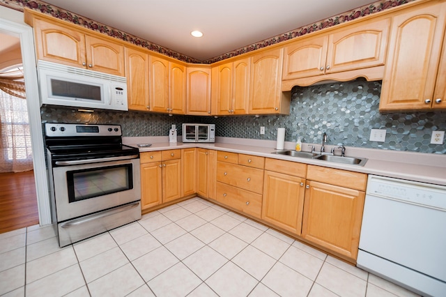 kitchen with light tile patterned floors, sink, tasteful backsplash, and white appliances