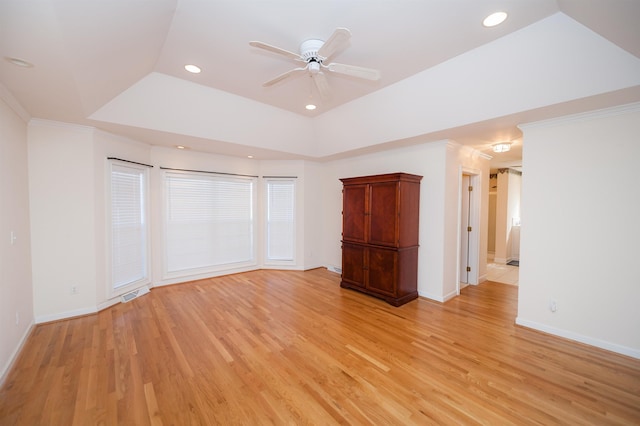 unfurnished bedroom with ceiling fan, ornamental molding, light hardwood / wood-style floors, and a raised ceiling