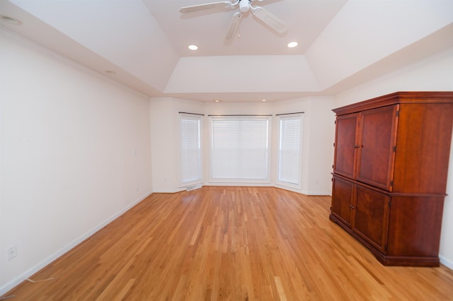 unfurnished bedroom with ceiling fan, light hardwood / wood-style flooring, and a raised ceiling