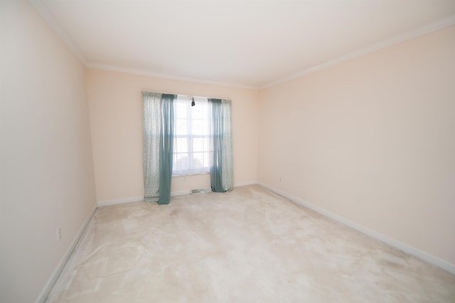 empty room featuring crown molding and light colored carpet