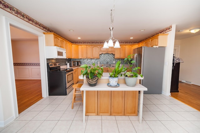 kitchen with light tile patterned flooring, a breakfast bar, stainless steel appliances, and a kitchen island