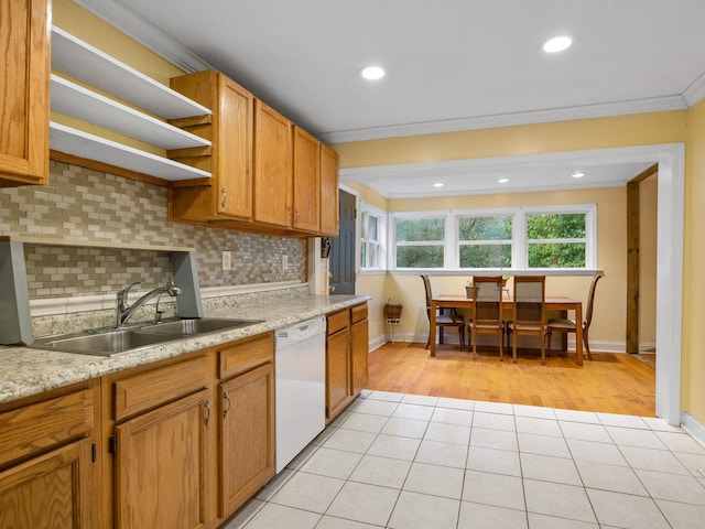 kitchen with dishwasher, sink, backsplash, ornamental molding, and light tile patterned floors