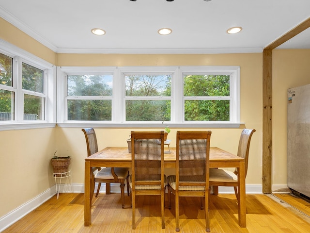 dining room featuring light wood-type flooring and ornamental molding