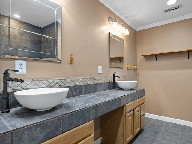 bathroom featuring tile patterned flooring, crown molding, tiled shower, and vanity