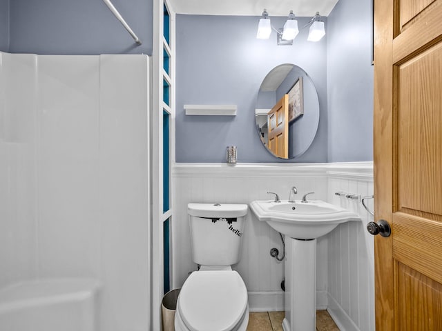 bathroom with toilet, tile patterned flooring, and sink