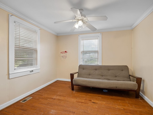 living area featuring ceiling fan, crown molding, and light hardwood / wood-style floors