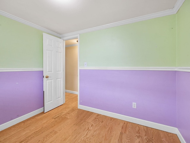 spare room with ornamental molding and light hardwood / wood-style flooring