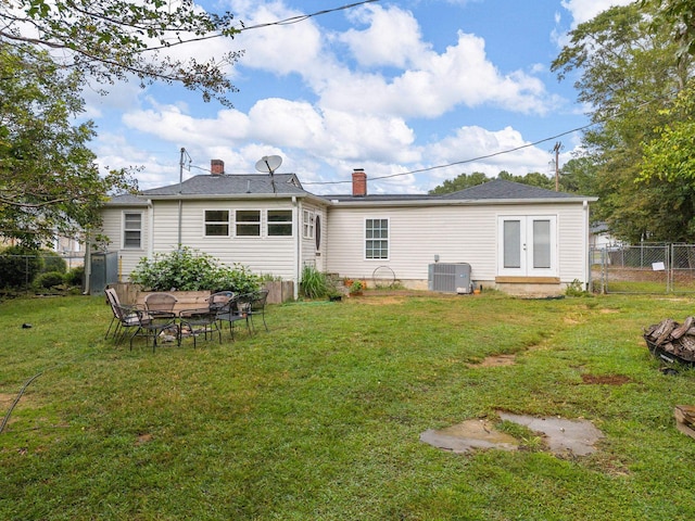 back of house featuring central AC, french doors, and a yard