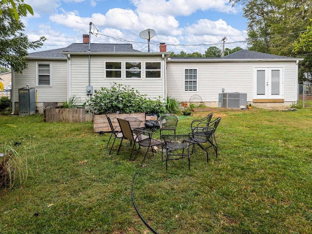 back of house with a yard, french doors, and central AC