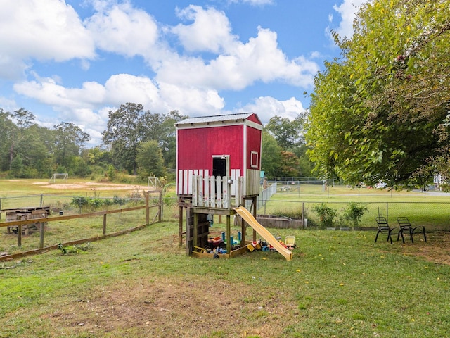 view of playground featuring a rural view and a yard