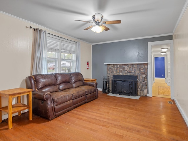 living room with light wood-type flooring, ceiling fan, and ornamental molding