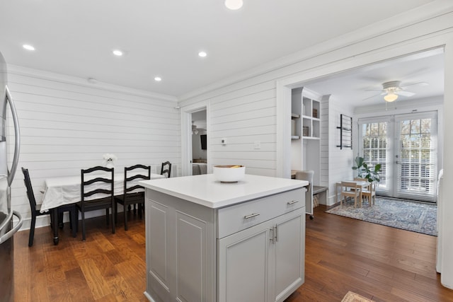 kitchen featuring ceiling fan, dark hardwood / wood-style flooring, ornamental molding, and a kitchen island