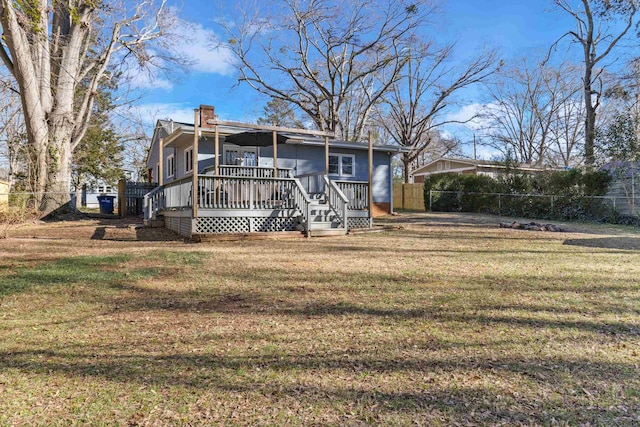 back of house featuring a deck and a lawn