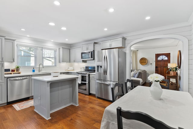 kitchen featuring gray cabinets, stainless steel appliances, a center island, dark wood-type flooring, and sink