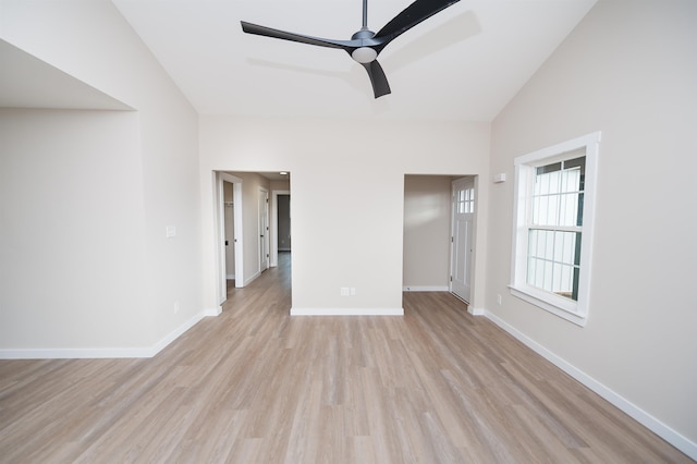 spare room with ceiling fan, light wood-type flooring, and vaulted ceiling