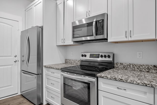 kitchen featuring light stone counters, light hardwood / wood-style floors, white cabinets, and stainless steel appliances