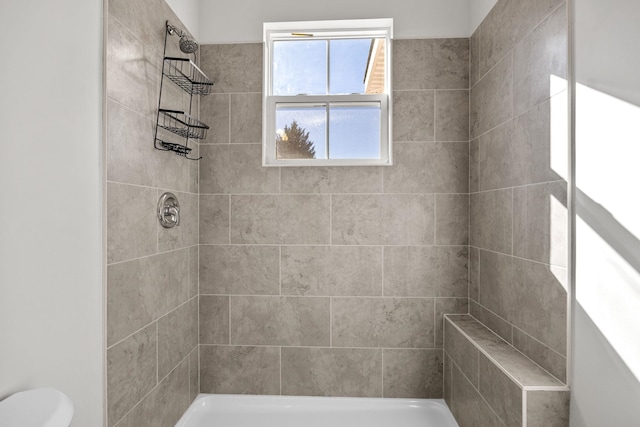 bathroom with toilet and tiled shower