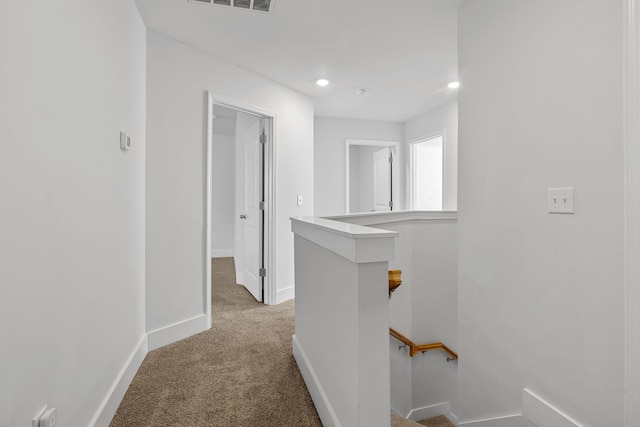 hallway featuring light colored carpet