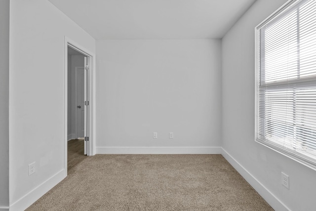 spare room featuring light colored carpet