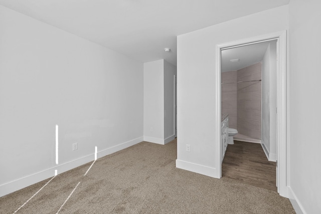 unfurnished bedroom with carpet and ensuite bathroom