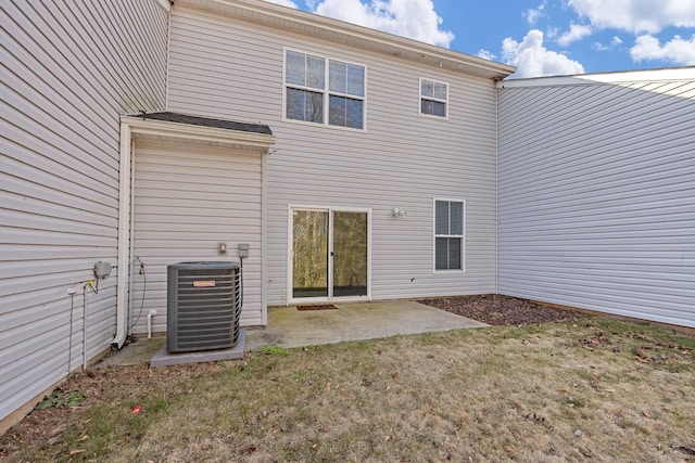 back of property with central AC unit, a yard, and a patio