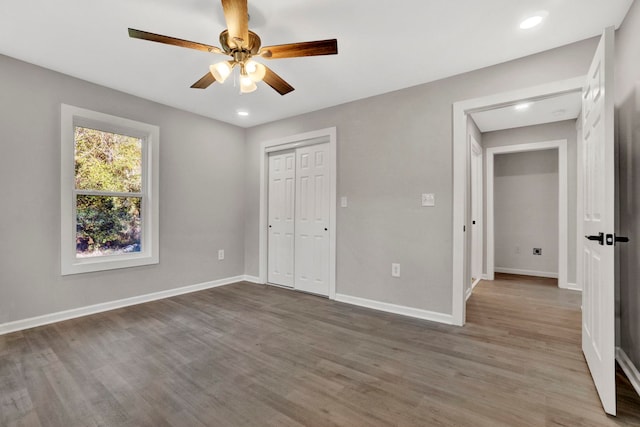 unfurnished bedroom with hardwood / wood-style floors, ceiling fan, and a closet