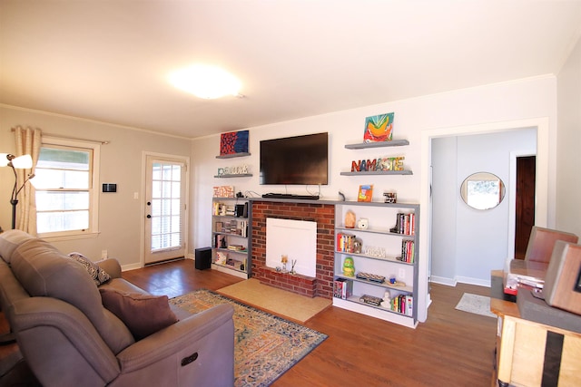 living room featuring a fireplace, dark hardwood / wood-style floors, and ornamental molding