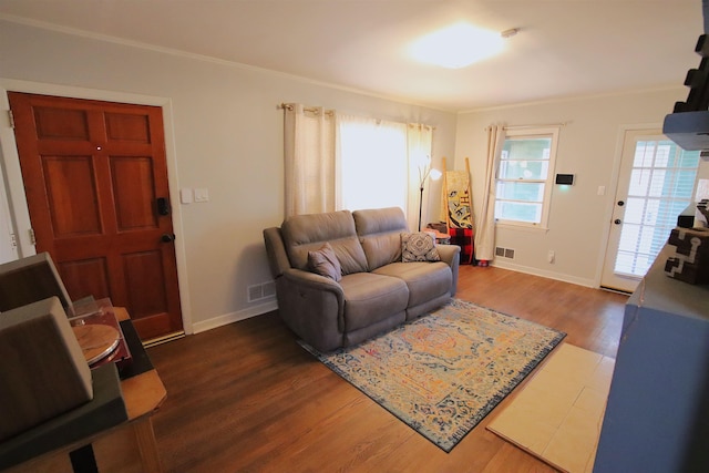 living room featuring plenty of natural light, dark hardwood / wood-style flooring, and crown molding