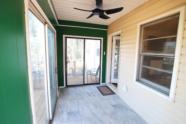 unfurnished sunroom featuring ceiling fan