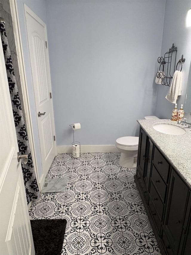 bathroom with toilet, tile patterned floors, and vanity