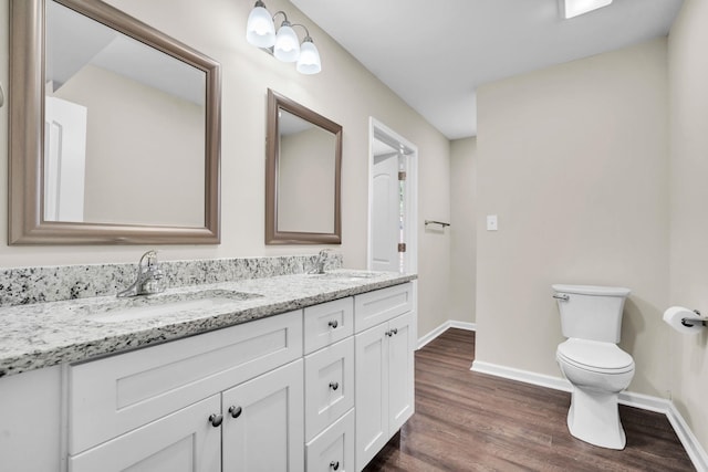 bathroom with wood-type flooring, toilet, and vanity