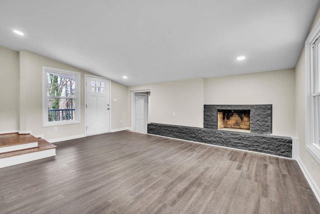 unfurnished living room with wood-type flooring and vaulted ceiling