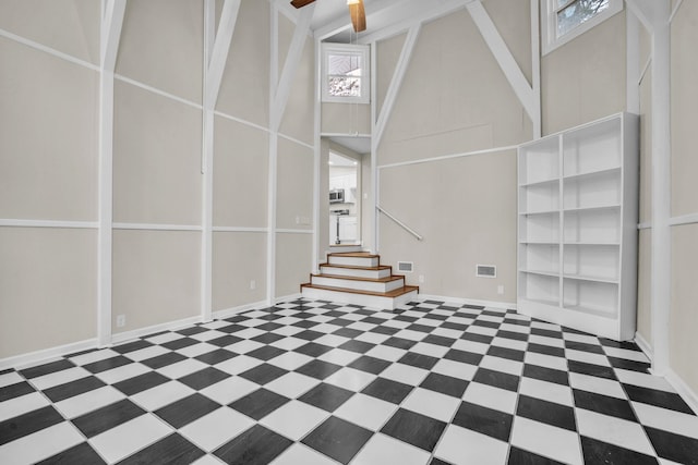 unfurnished living room featuring high vaulted ceiling, ceiling fan, and a wealth of natural light