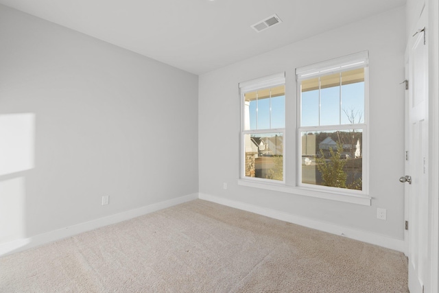 unfurnished room featuring carpet flooring, visible vents, and baseboards