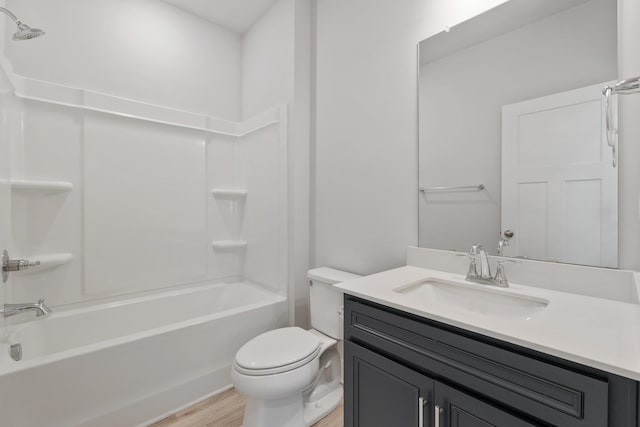 full bath with toilet,  shower combination, wood finished floors, and vanity