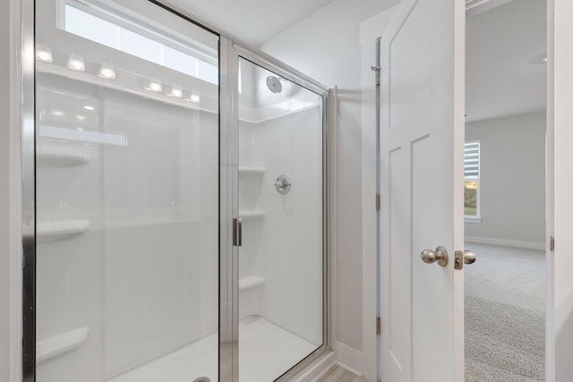 full bath featuring a stall shower and baseboards