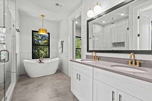 bathroom with vanity, a wealth of natural light, shower with separate bathtub, and tile walls