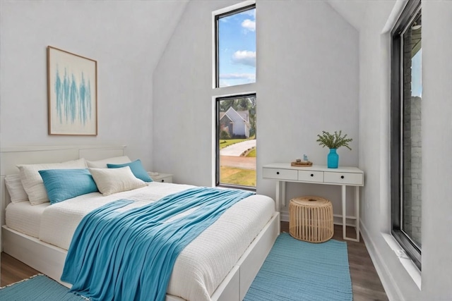 bedroom with dark hardwood / wood-style floors and vaulted ceiling