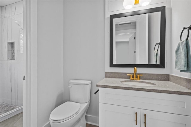 bathroom featuring toilet, tile patterned floors, tiled shower, and vanity