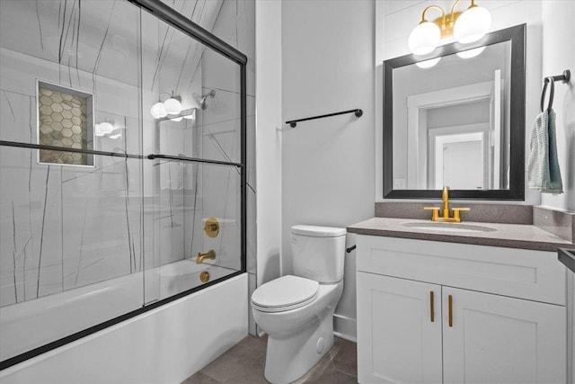 full bathroom featuring combined bath / shower with glass door, vanity, tile patterned floors, and toilet