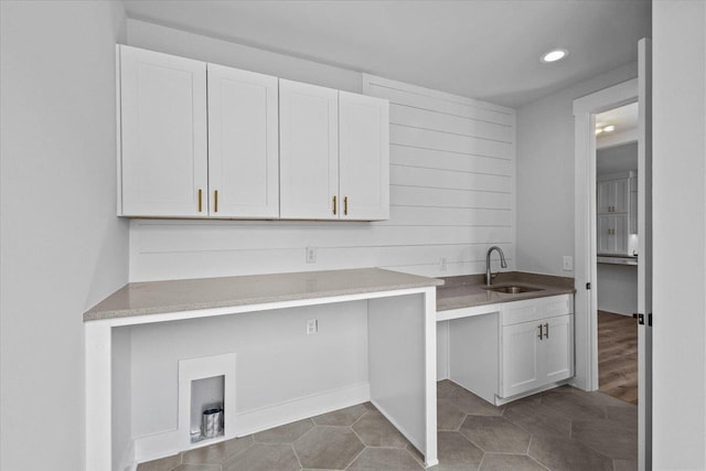 clothes washing area featuring cabinets, sink, and light tile patterned flooring