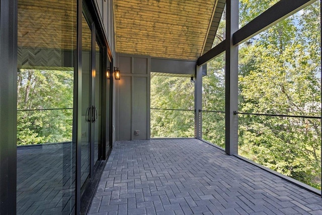 unfurnished sunroom featuring vaulted ceiling